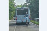 Момче с тротинетка изпреварва автобус по пътя, кара я на една гума