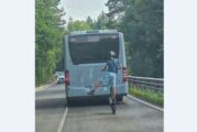 Момче с тротинетка изпреварва автобус по пътя, кара я на една гума